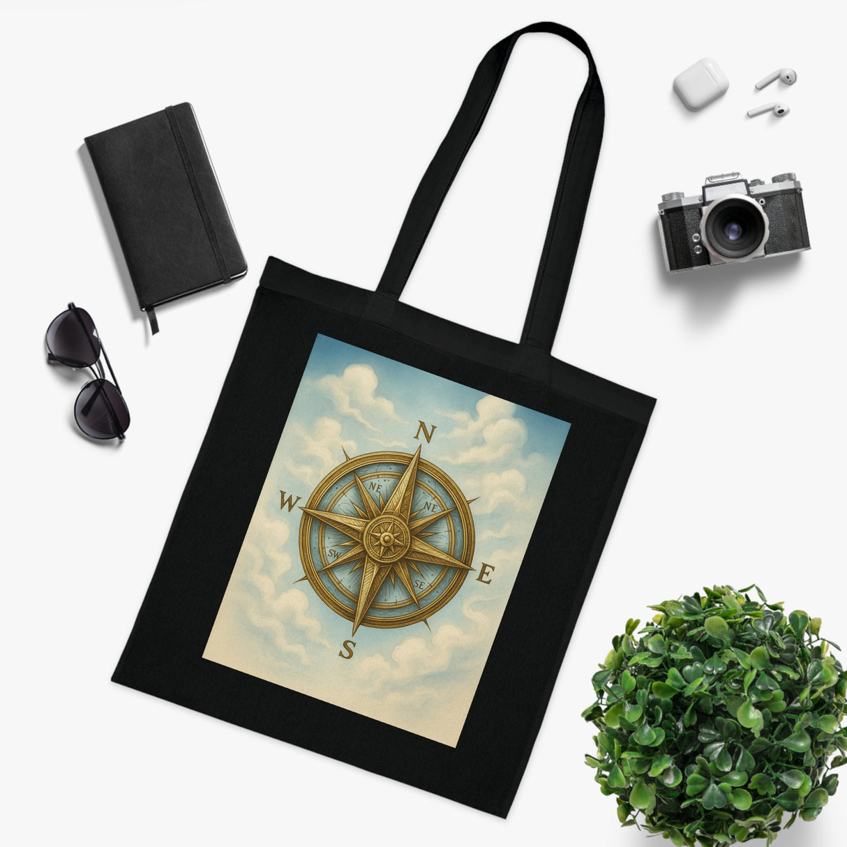 Vintage Compass Cotton Tote Bag beside travel essentials demonstrating its versatility.