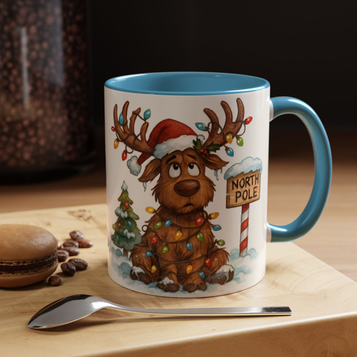 Close-up of the Christmas Reindeer Coffee Mug featuring a reindeer beside a North Pole sign and tiny tree.