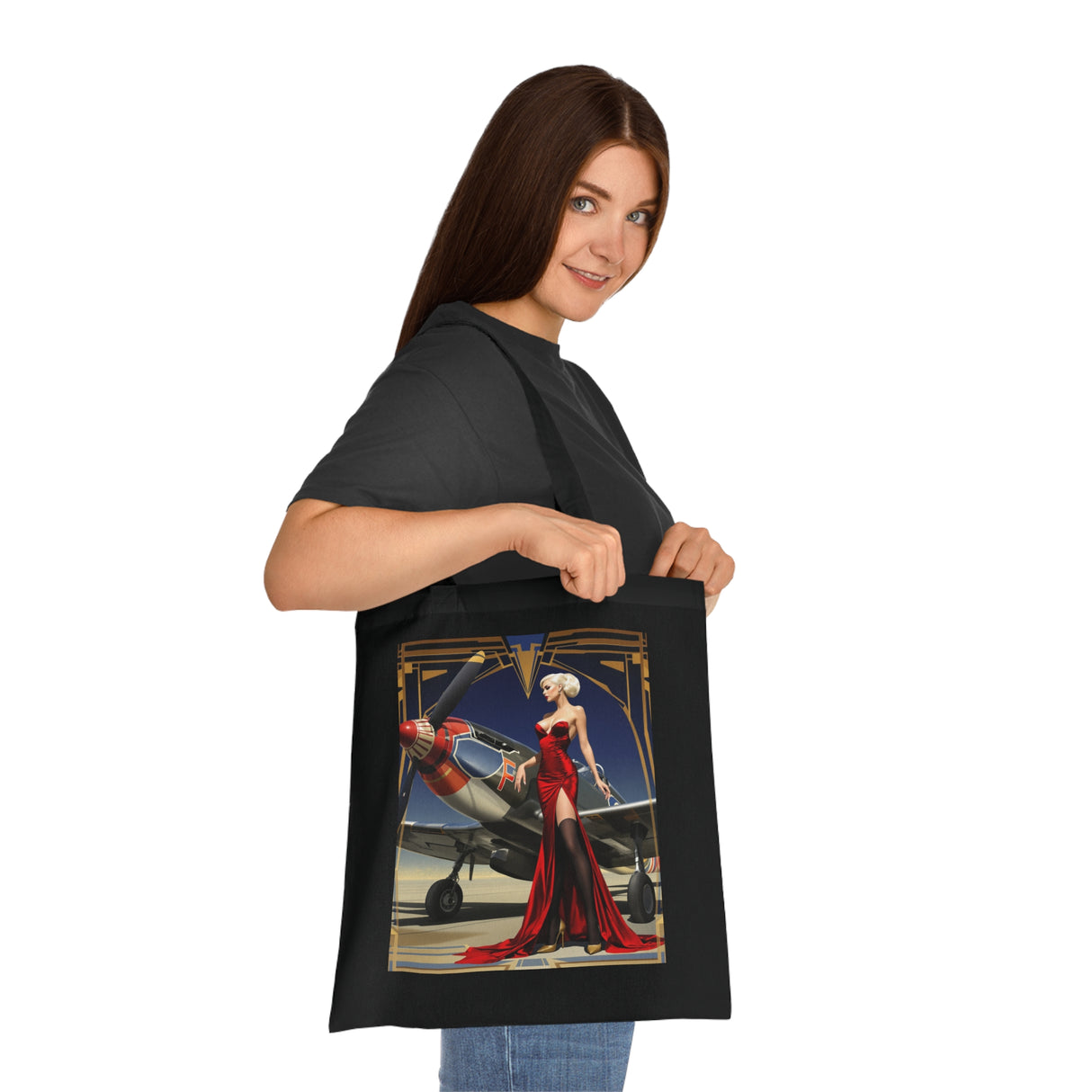 A casual outdoor scene with the Vintage Pin-Up Plane Tote — Red Dress Aviation Cotton Tote Bag hanging from a shoulder, emphasizing its stylish design.