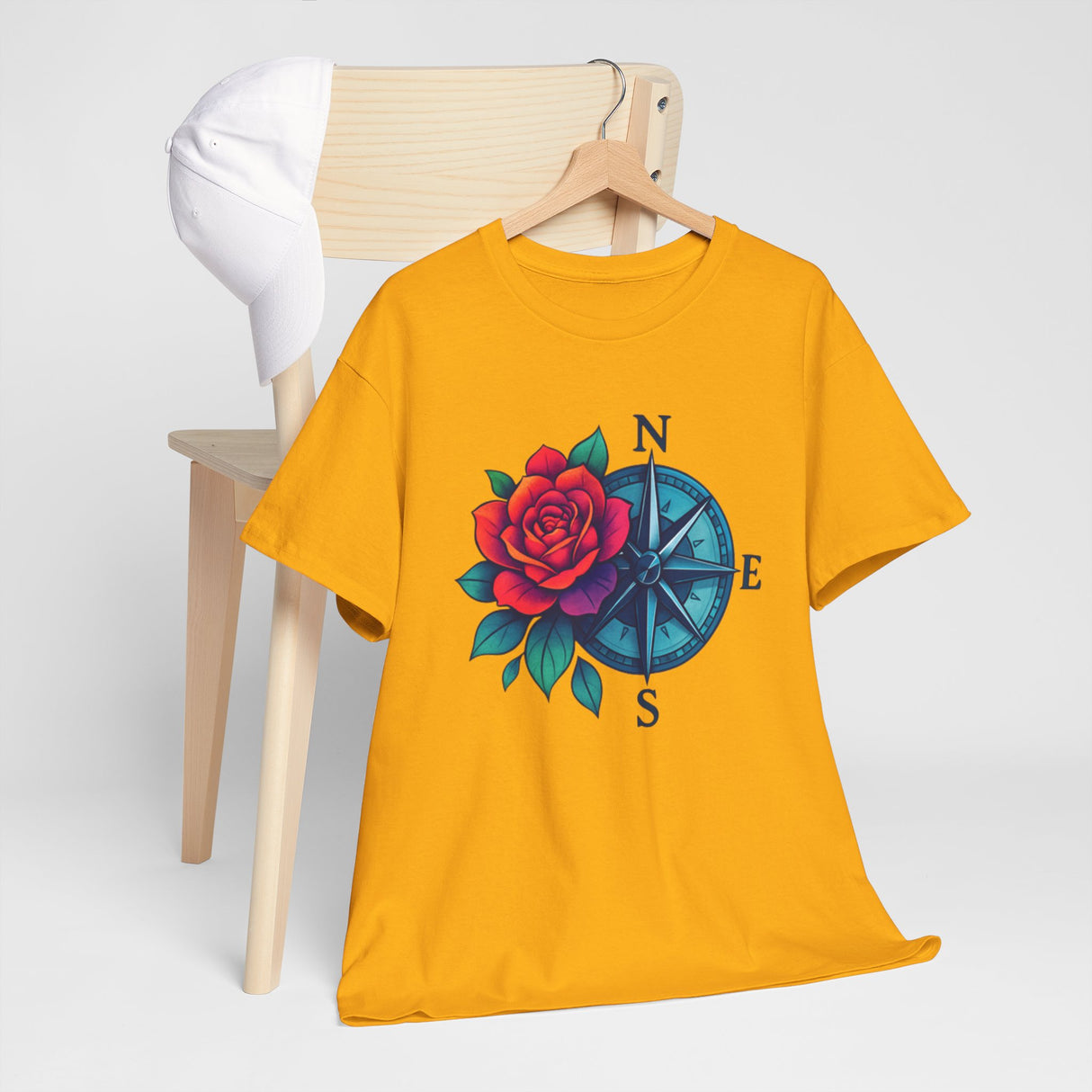 The Compass Rose Tee — Red Rose Nautical Compass Graphic T-Shirt artistically laid on a travel journal.