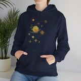 Celestial Compass Hoodie with gold motifs displayed in a natural outdoor setting, highlighting its cozy appeal.