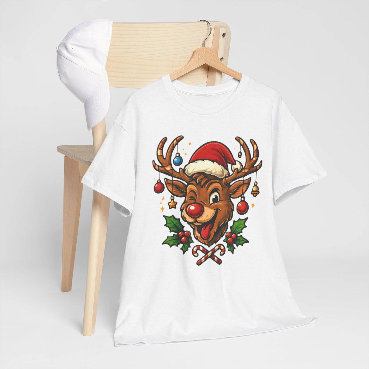 The Christmas Reindeer Tee worn by a person standing by a decorated Christmas tree, enhancing the festive vibe.